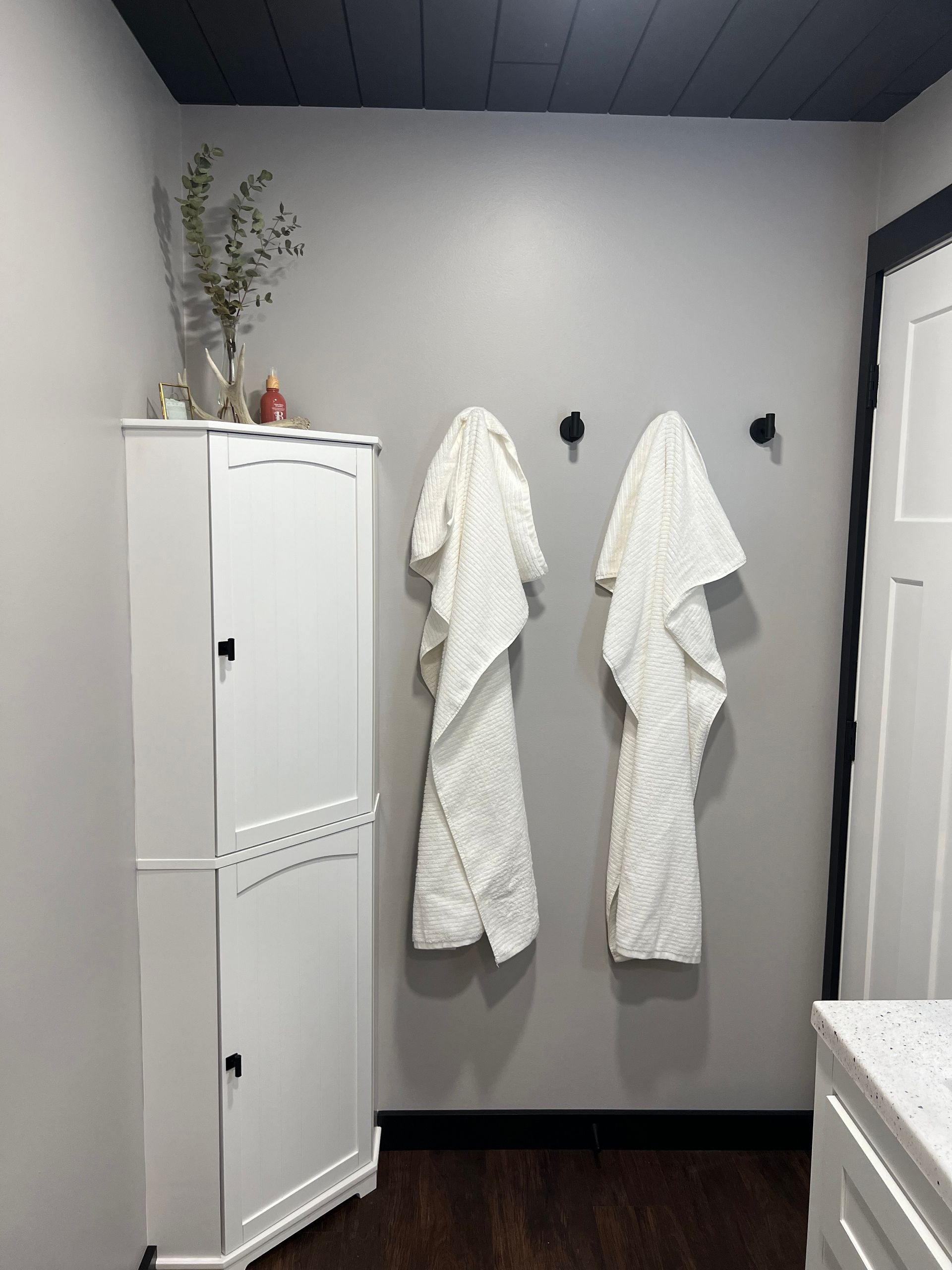 A bathroom with two white towels hanging on the wall.