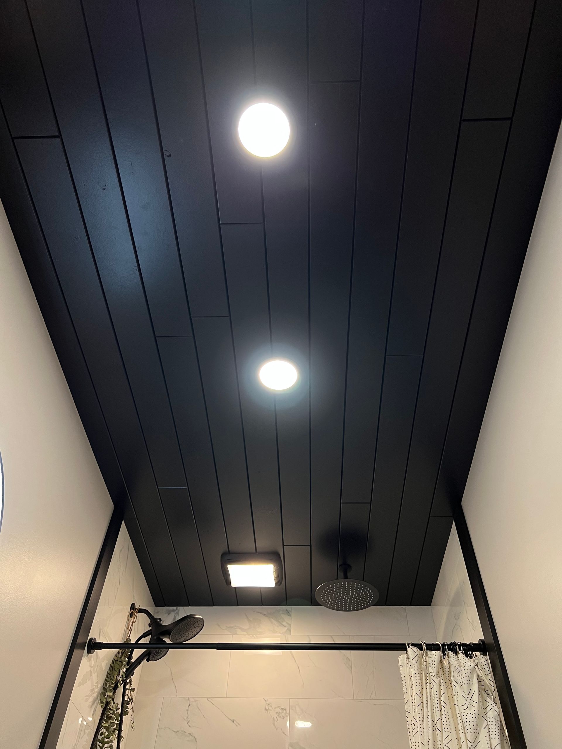A bathroom with a black ceiling and a shower curtain.