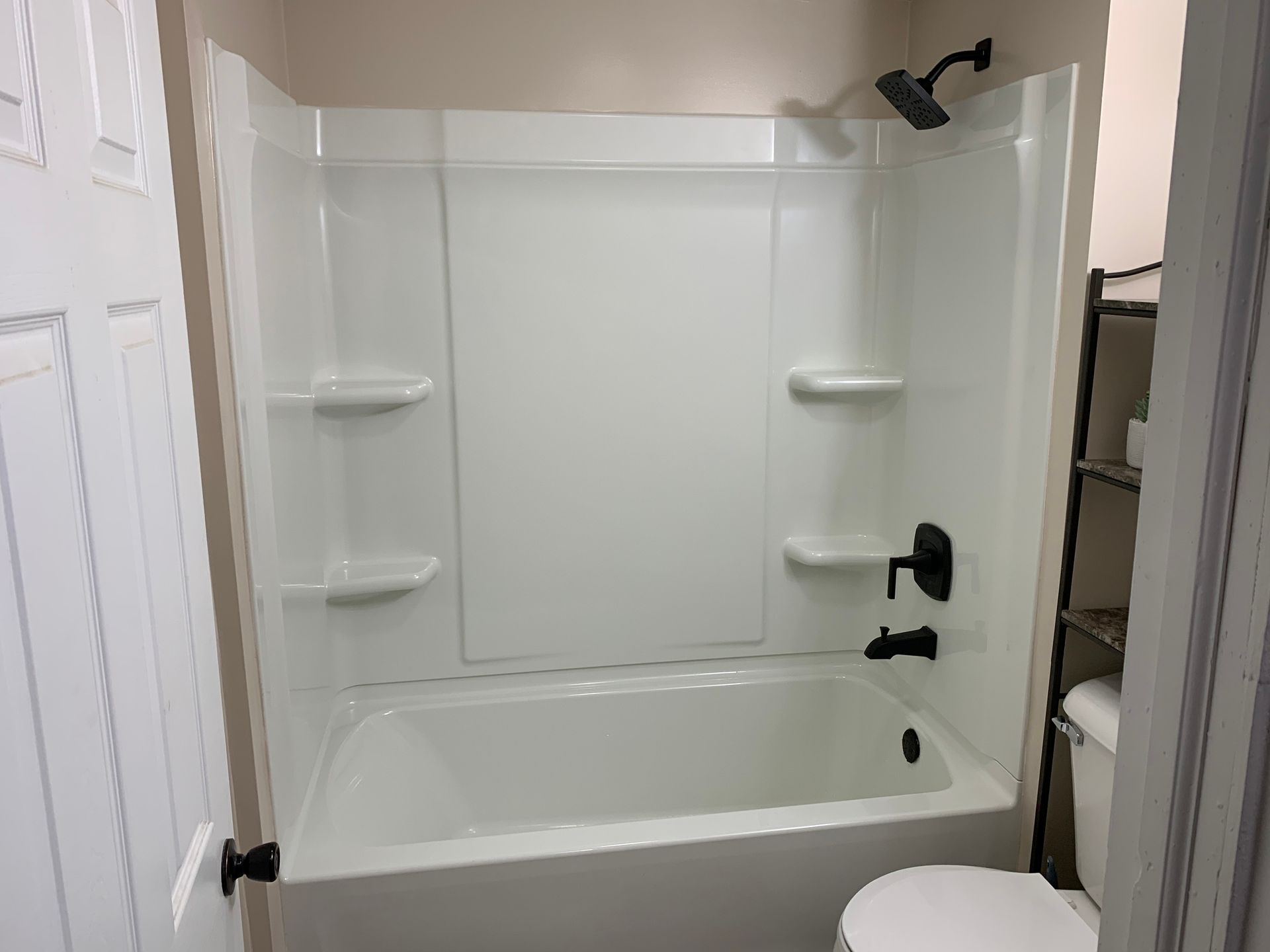 A bathroom with a bathtub , toilet and shower.