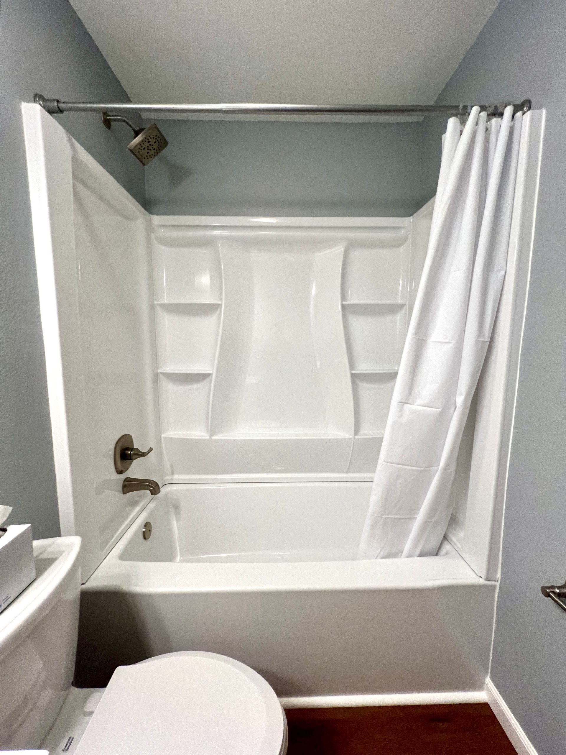 A bathroom with a bathtub a toilet and a shower