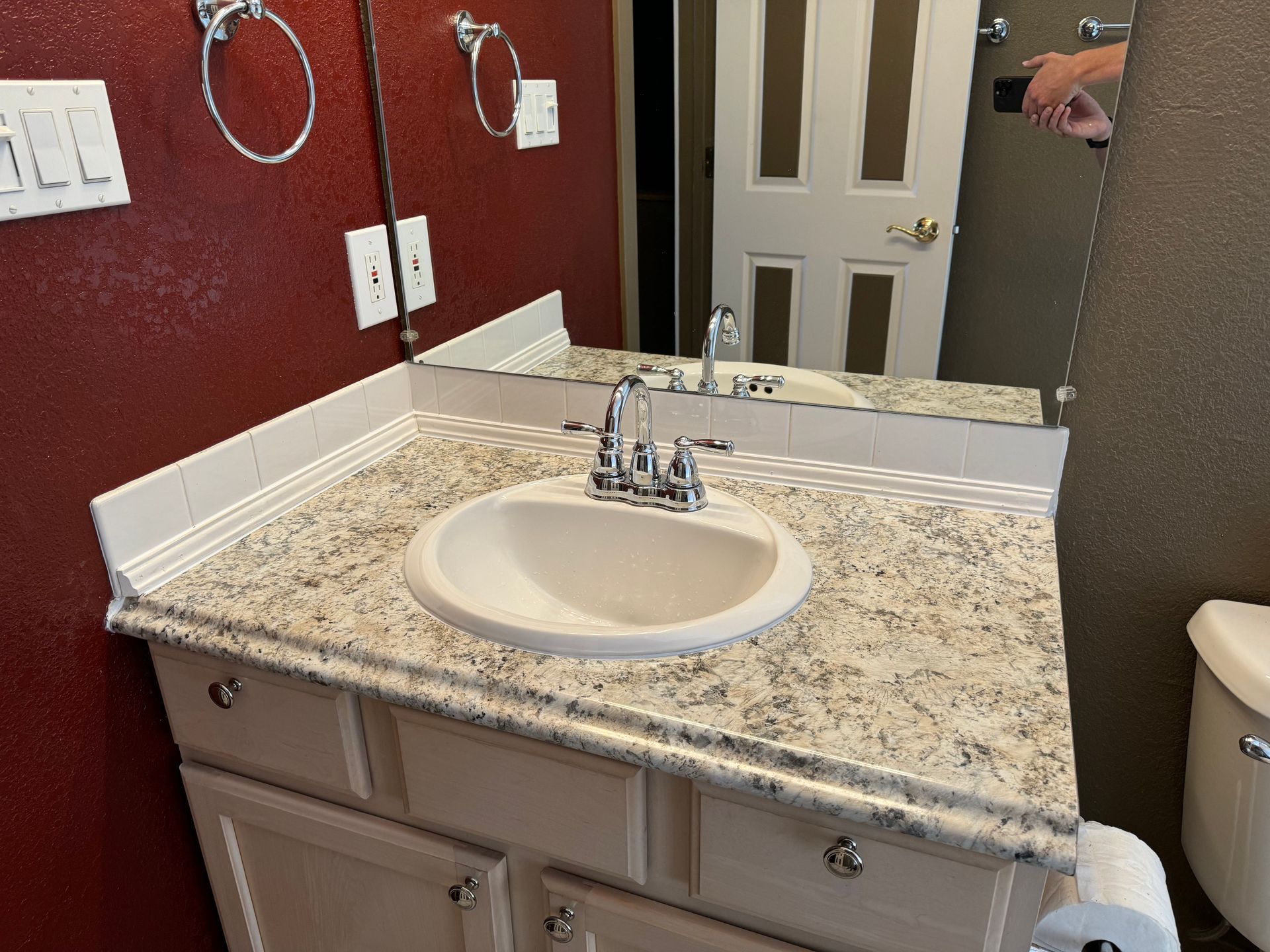 A bathroom with a sink a toilet and a mirror