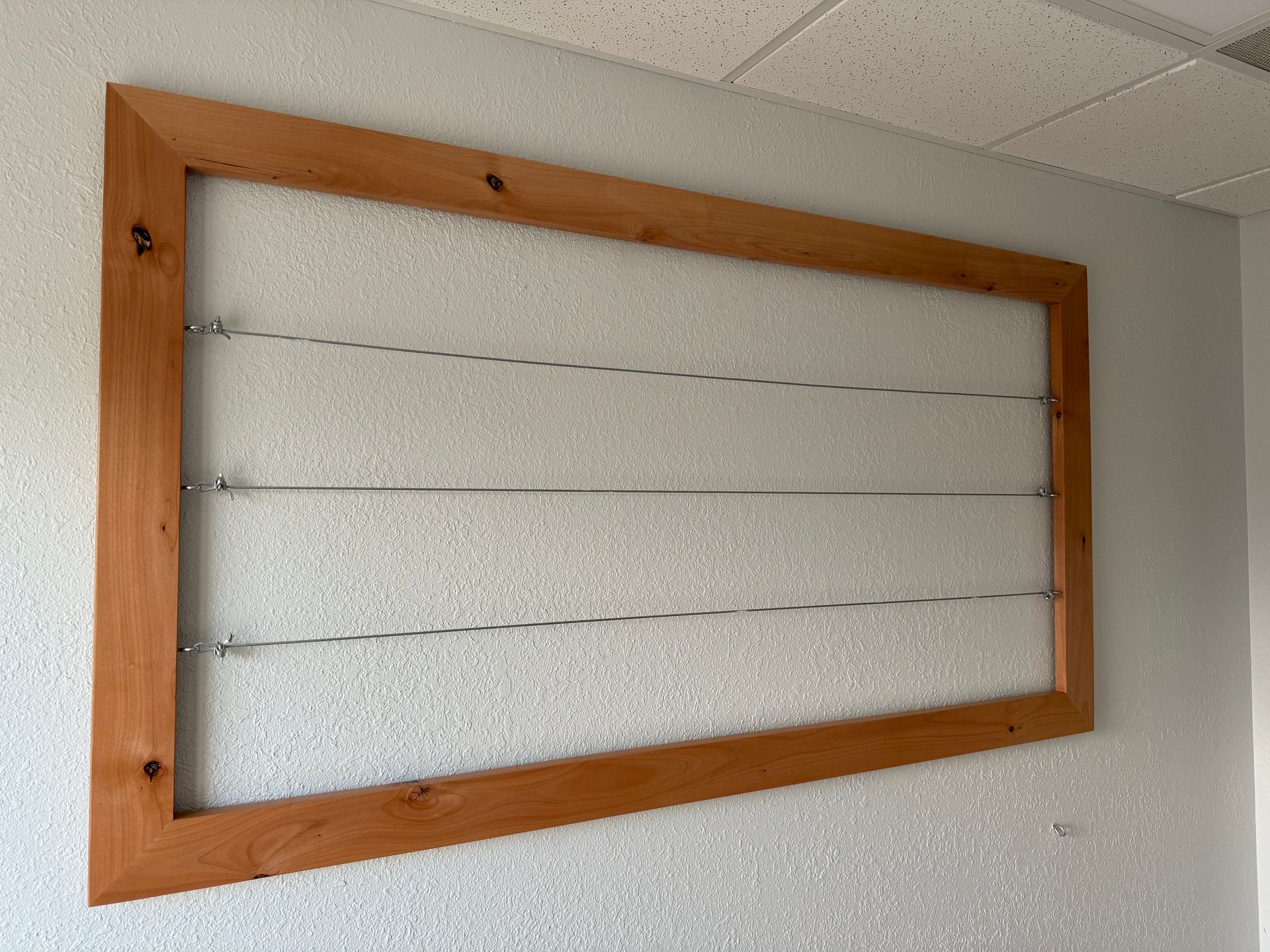 A wooden frame is hanging on a white wall