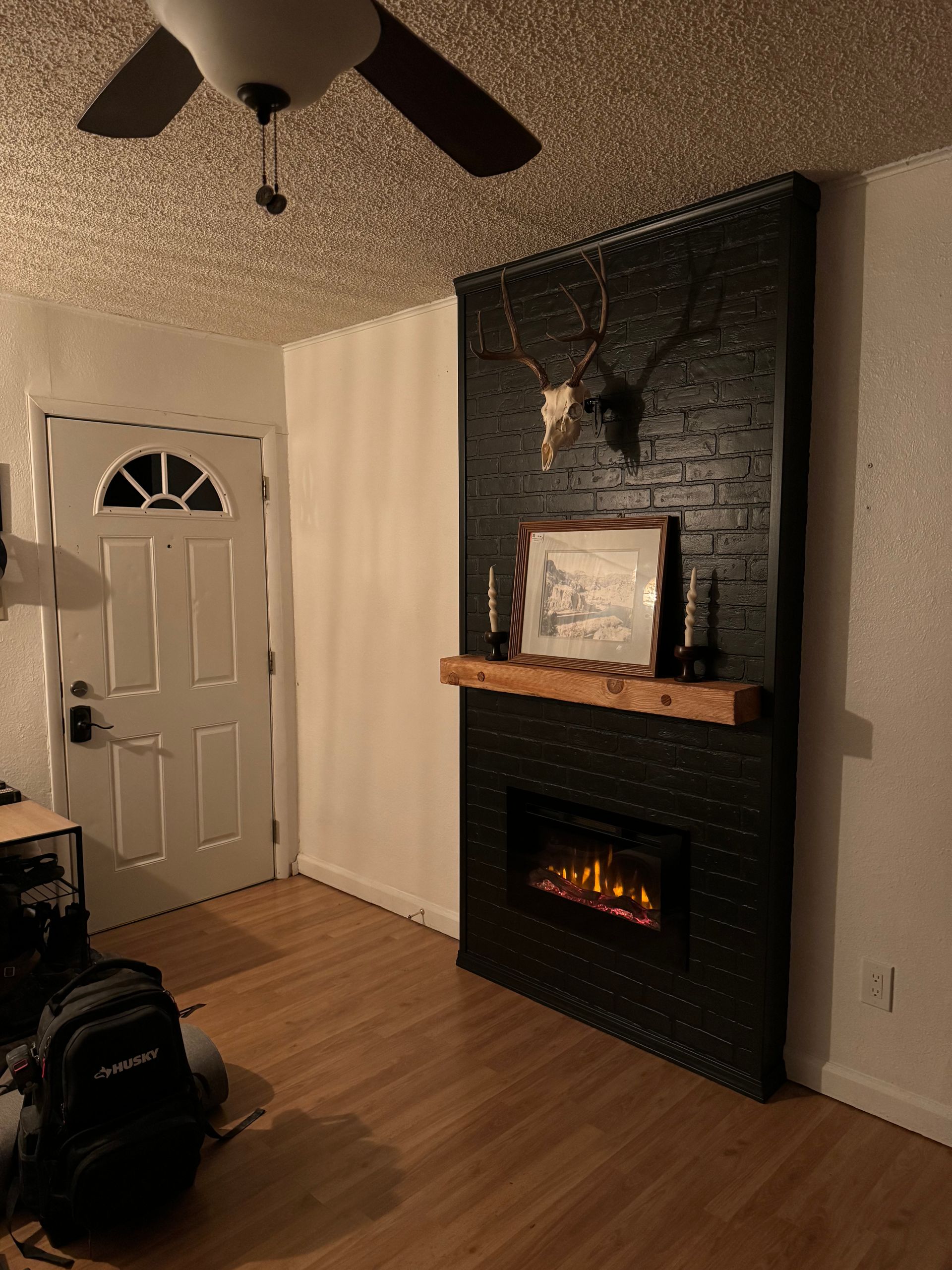 A living room with a fireplace and a ceiling fan.