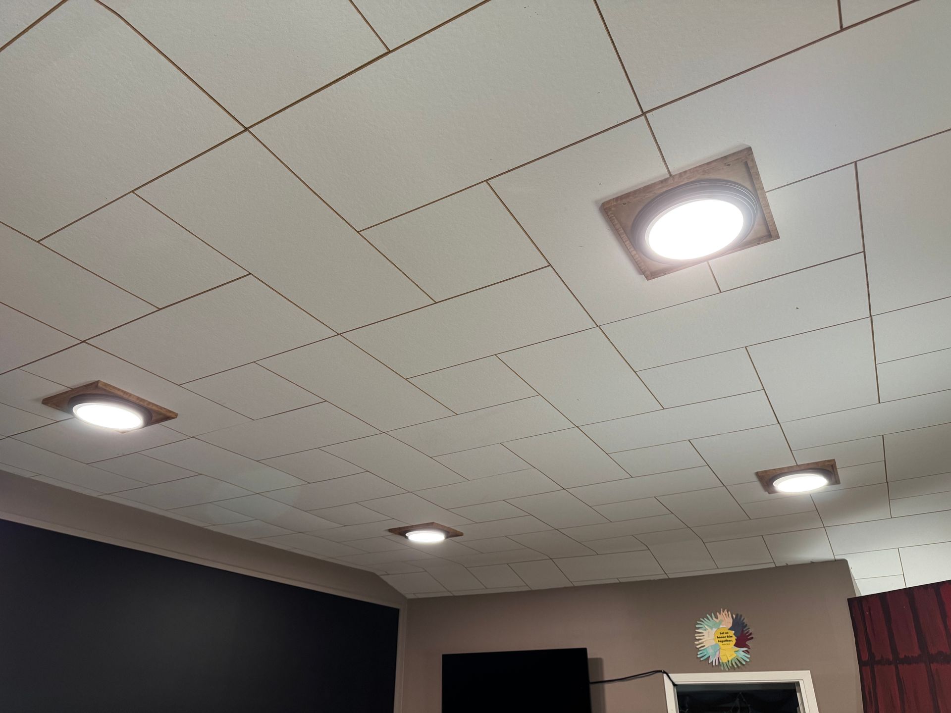There are three lights on the ceiling of a room.