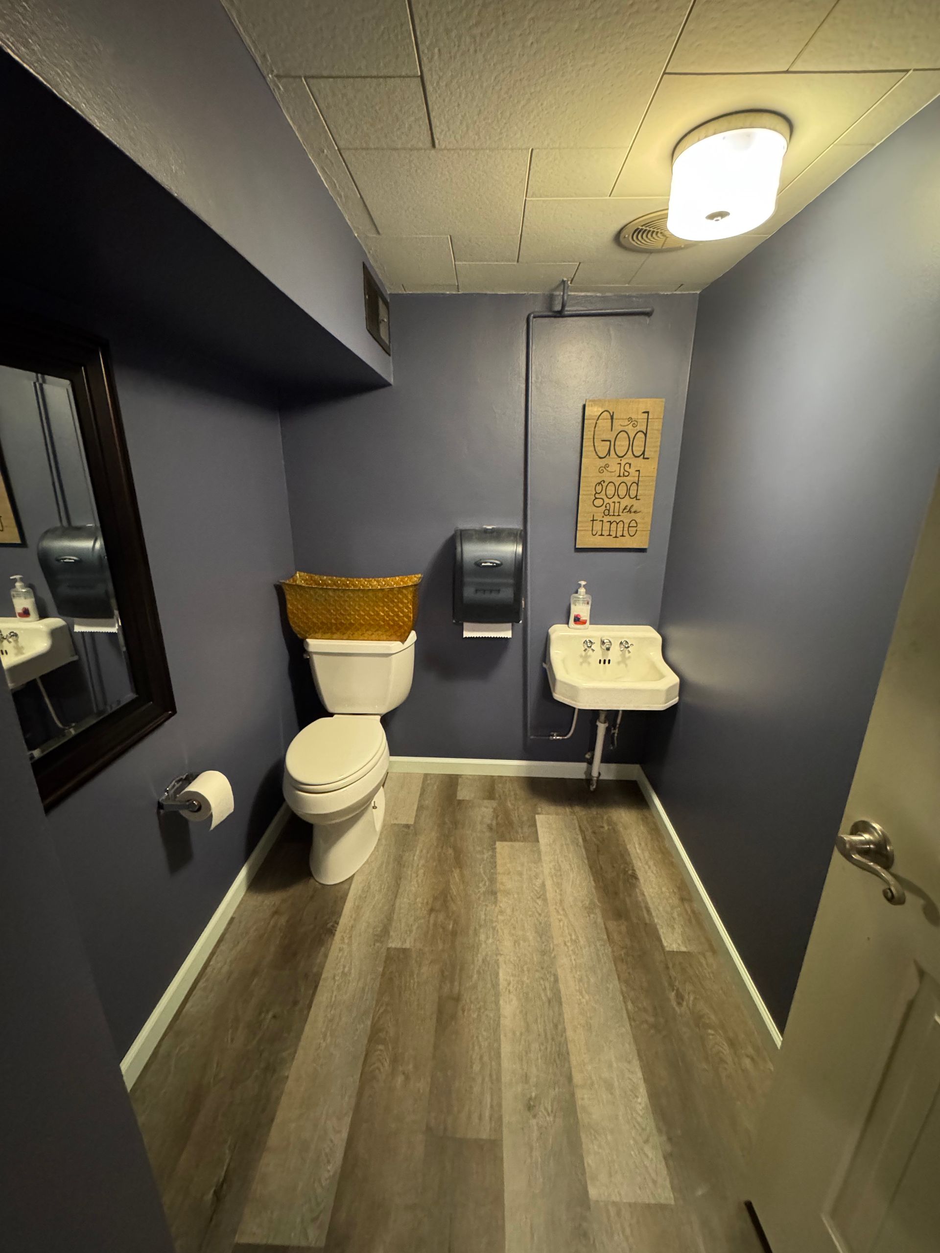 A bathroom with a toilet , sink and mirror