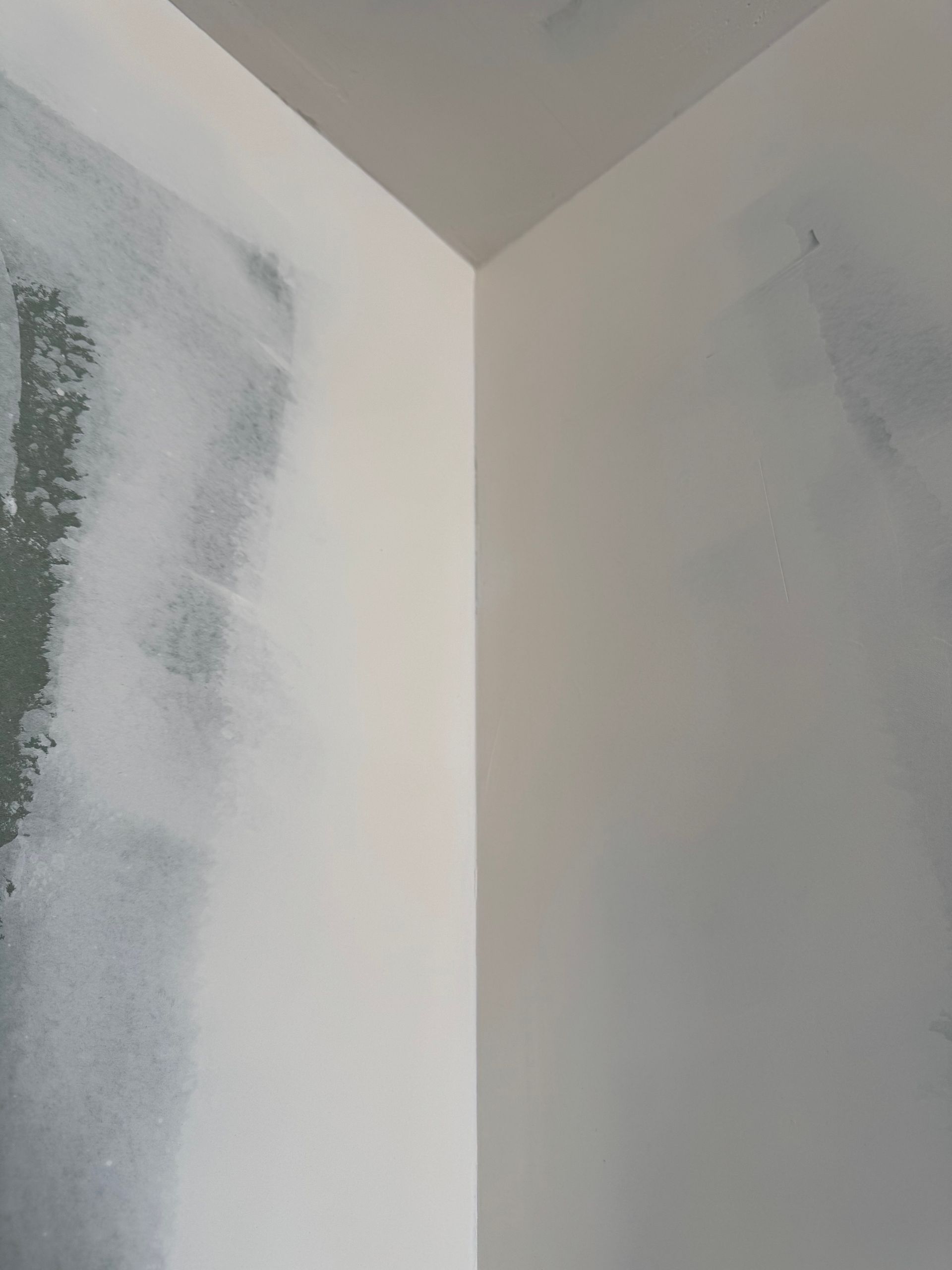 A corner of a room with a picture on the wall.