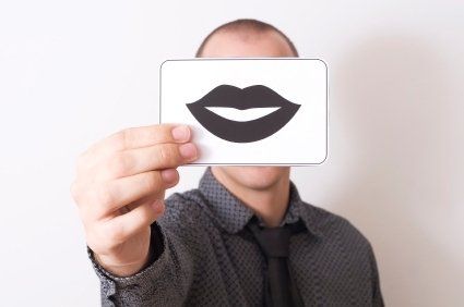 Person holding a drawing of a pair of lips in front of their face.