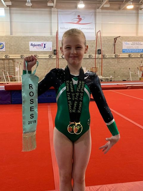 Gymnast with two medals smiling after their competition