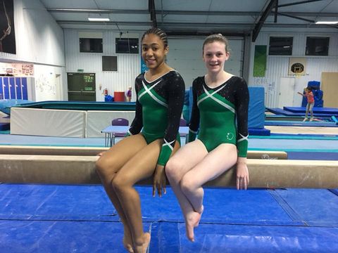 Gymnasts sat on a beam after competing at the twin piece competition