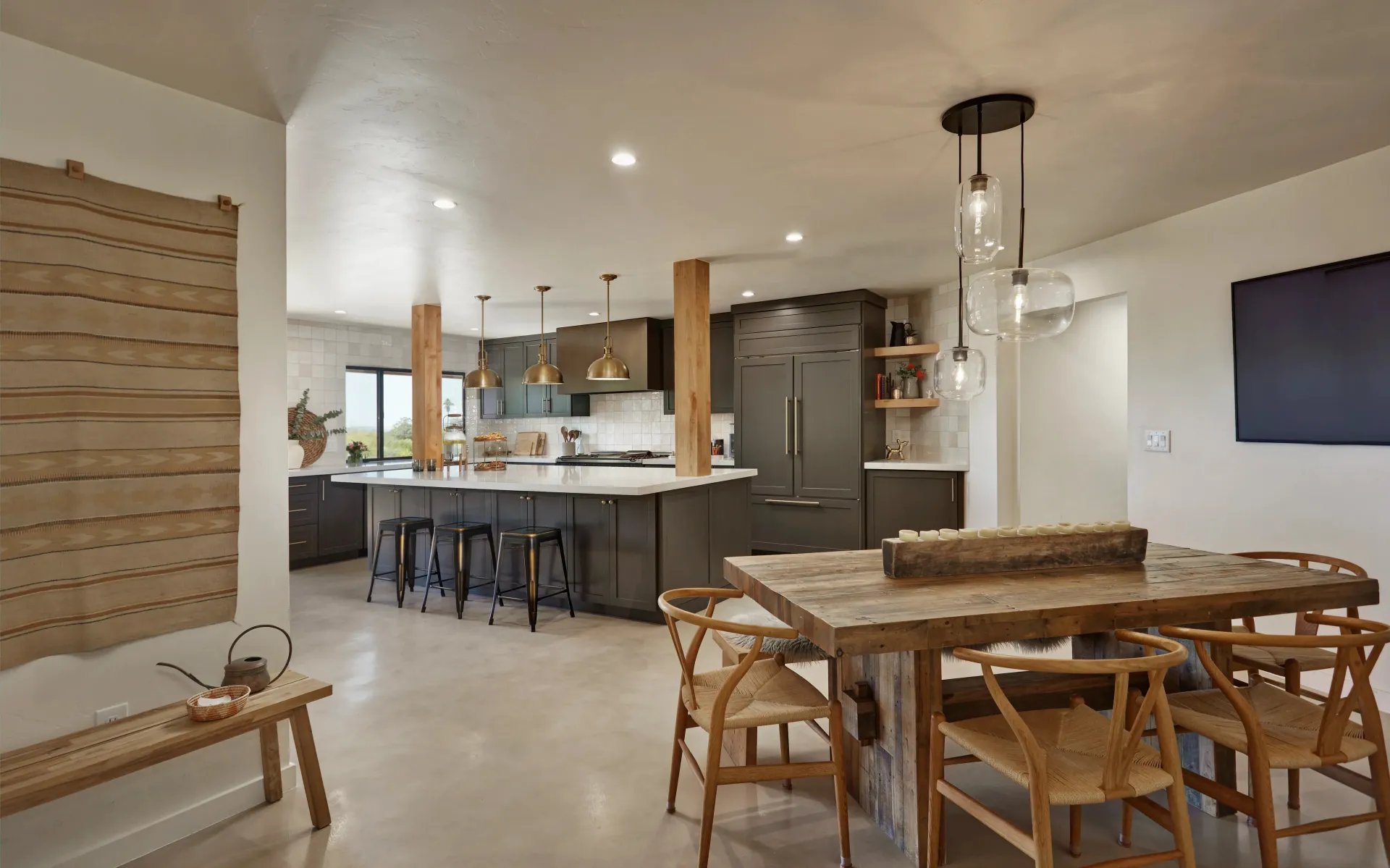 Modern kitchen with large island, dark cabinetry, gray countertop, and bar stools.