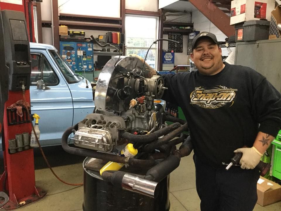 Man, Potentially an Engine Builder or Mechanic, in a Garage Setting with a Custom Air-Cooled Engine | Joe’s Garage Inc.