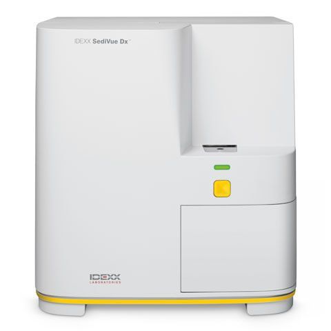 White medical analyzer device with a yellow button and green indicator on the front