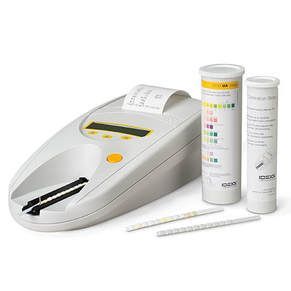 Blood glucose meter with test strips and two test strip containers on a white background
