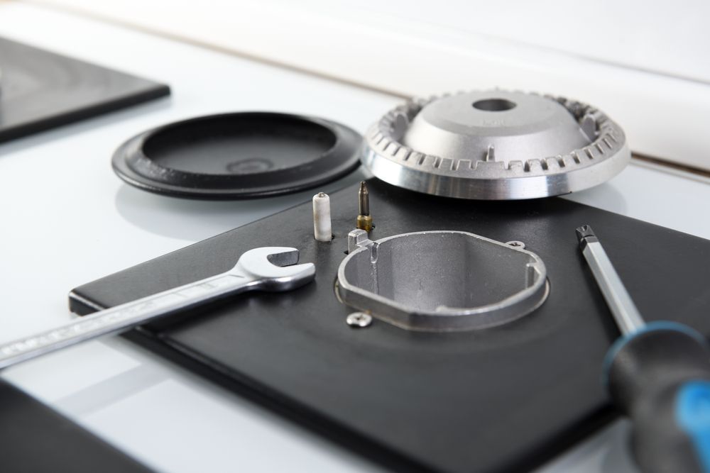 Gas Stove Burner Parts Laid Out With Tools on Stovetop — Auto Marvel In Mount Saint John, QLD