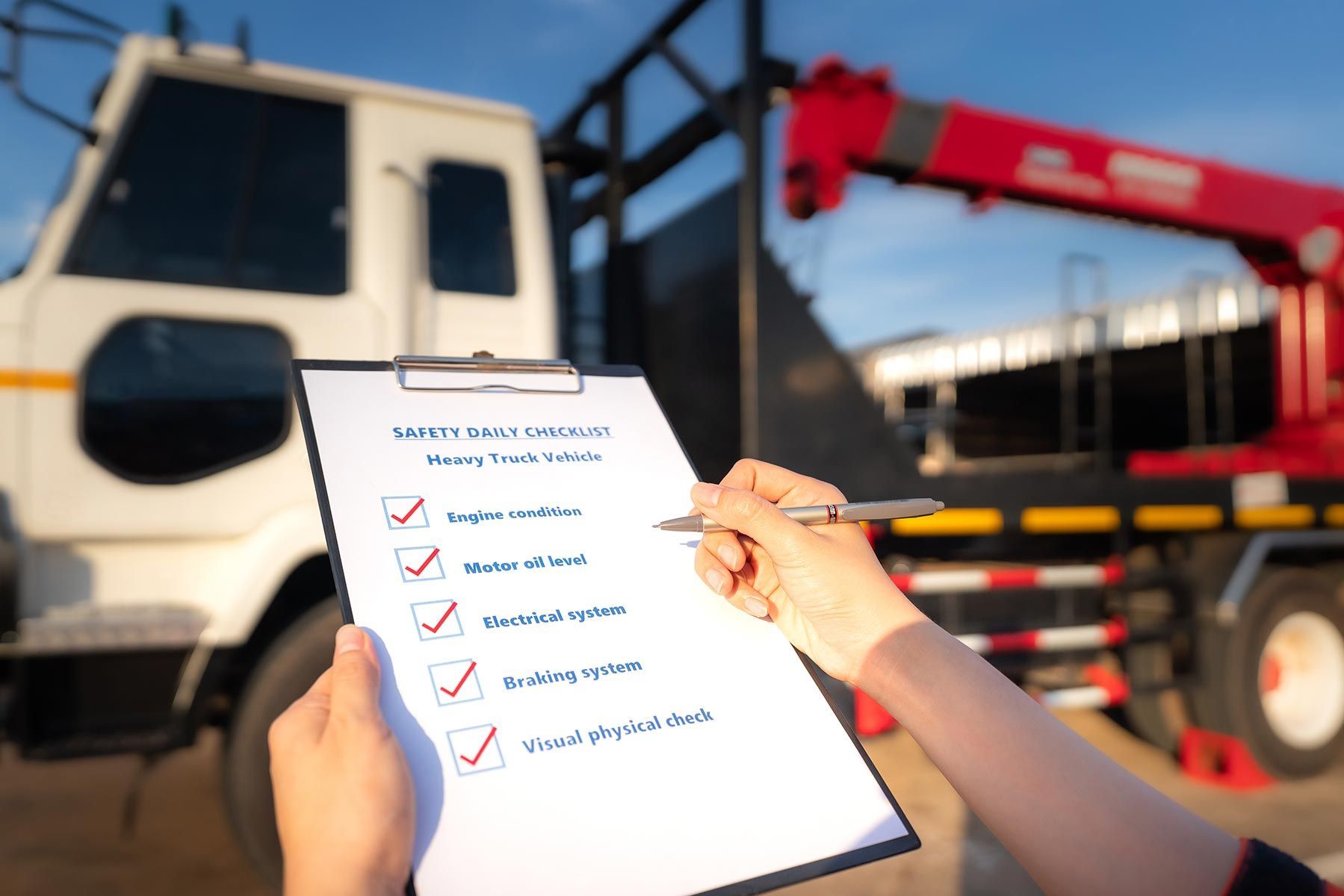 A Person Is Holding A Clipboard With A Checklist On It In Front Of A Truck — Auto Marvel In Mount Saint John, QLD