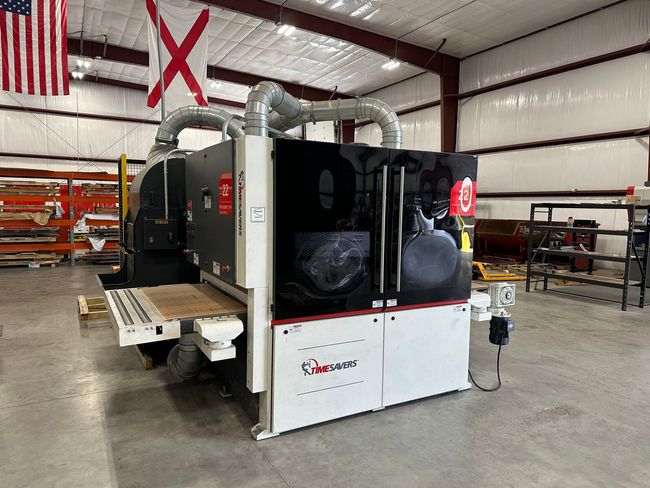 Large industrial wood sanding machine in a workshop setting.