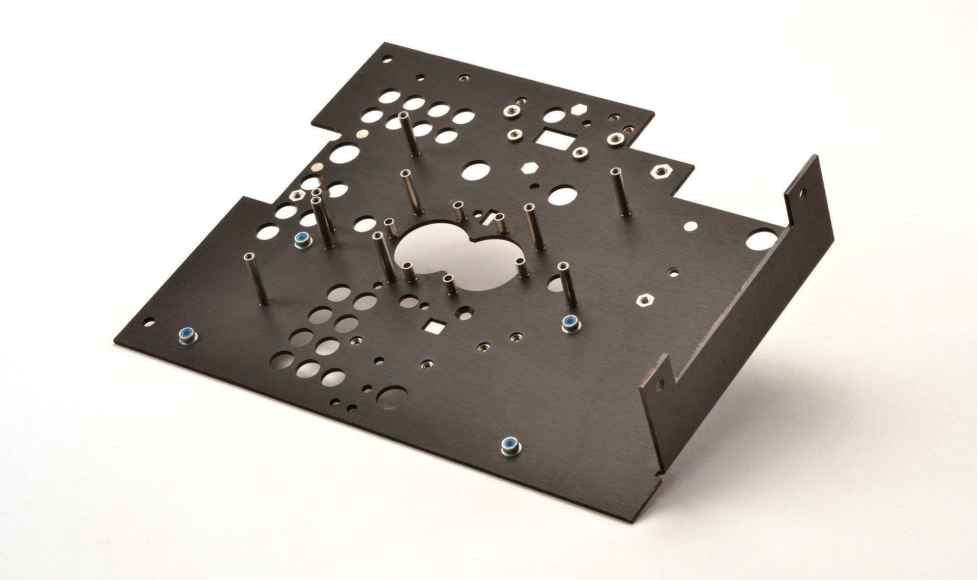 Black metal sheet with holes and bent edges, likely a component of an electronic device.