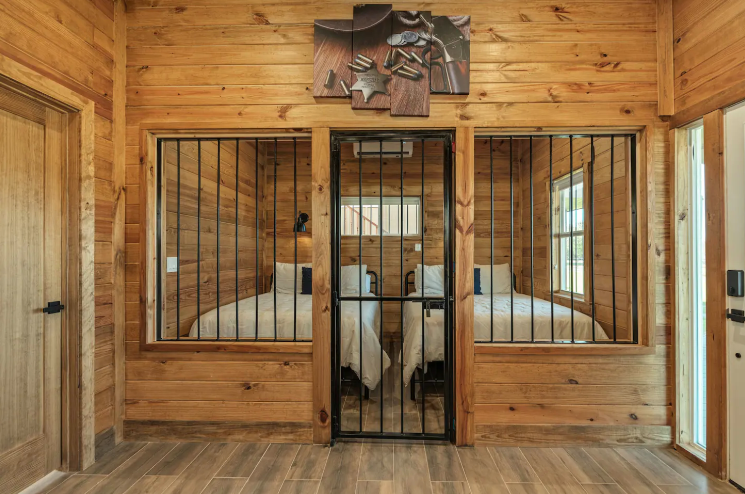 A wooden cabin with two beds and a prison cell.