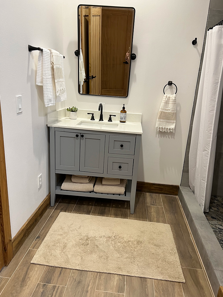 A bathroom with a sink , mirror , and rug.