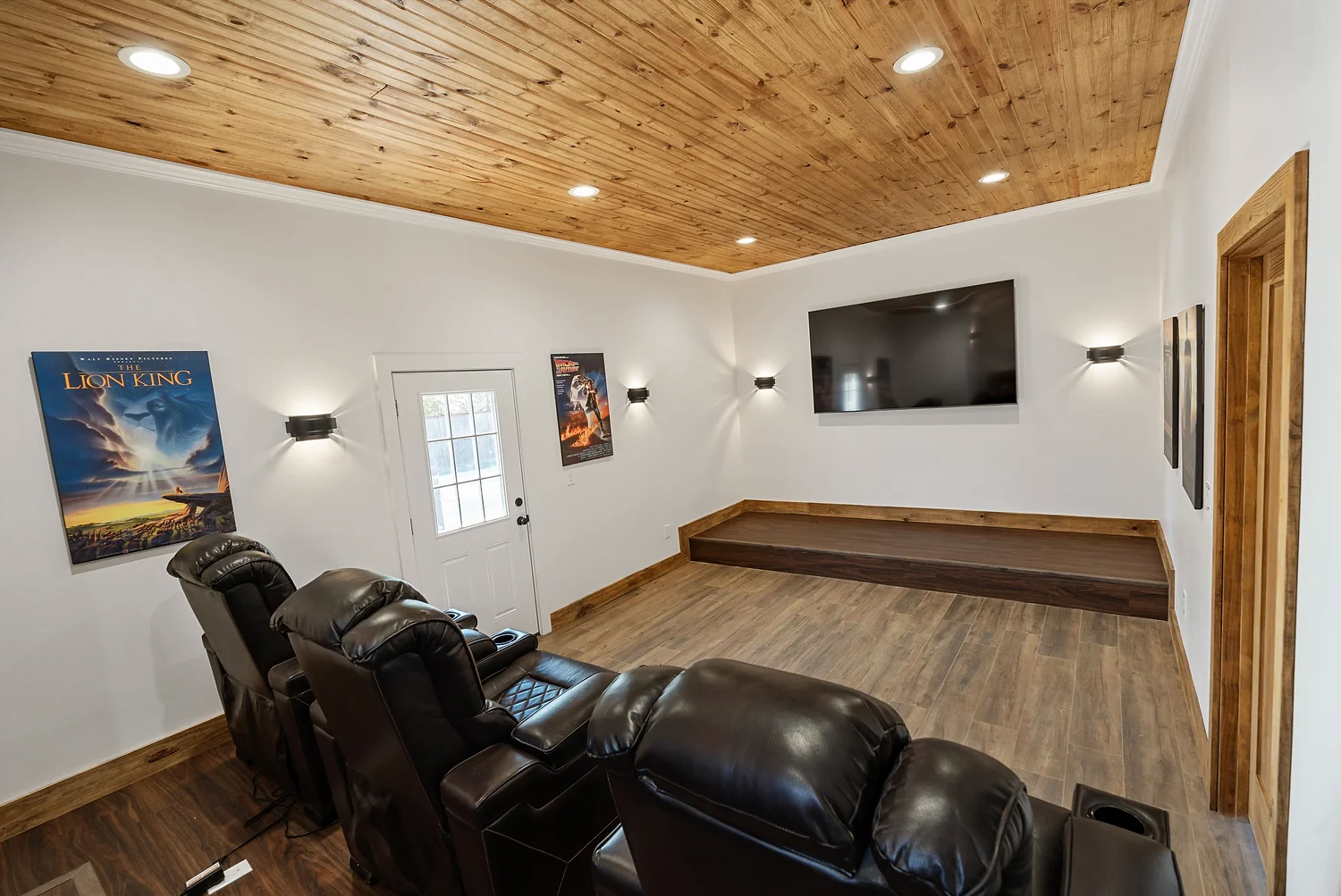A living room with a couch , chairs and a flat screen tv.