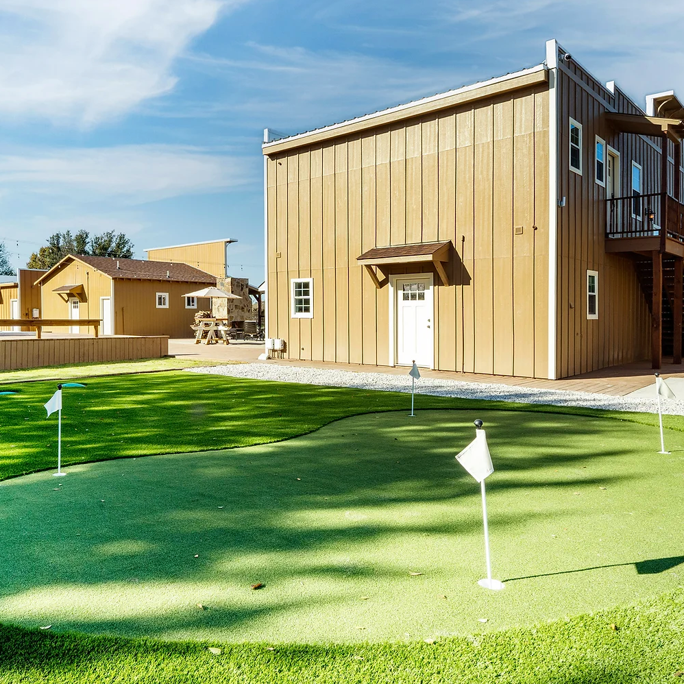 A house with a putting green in front of it