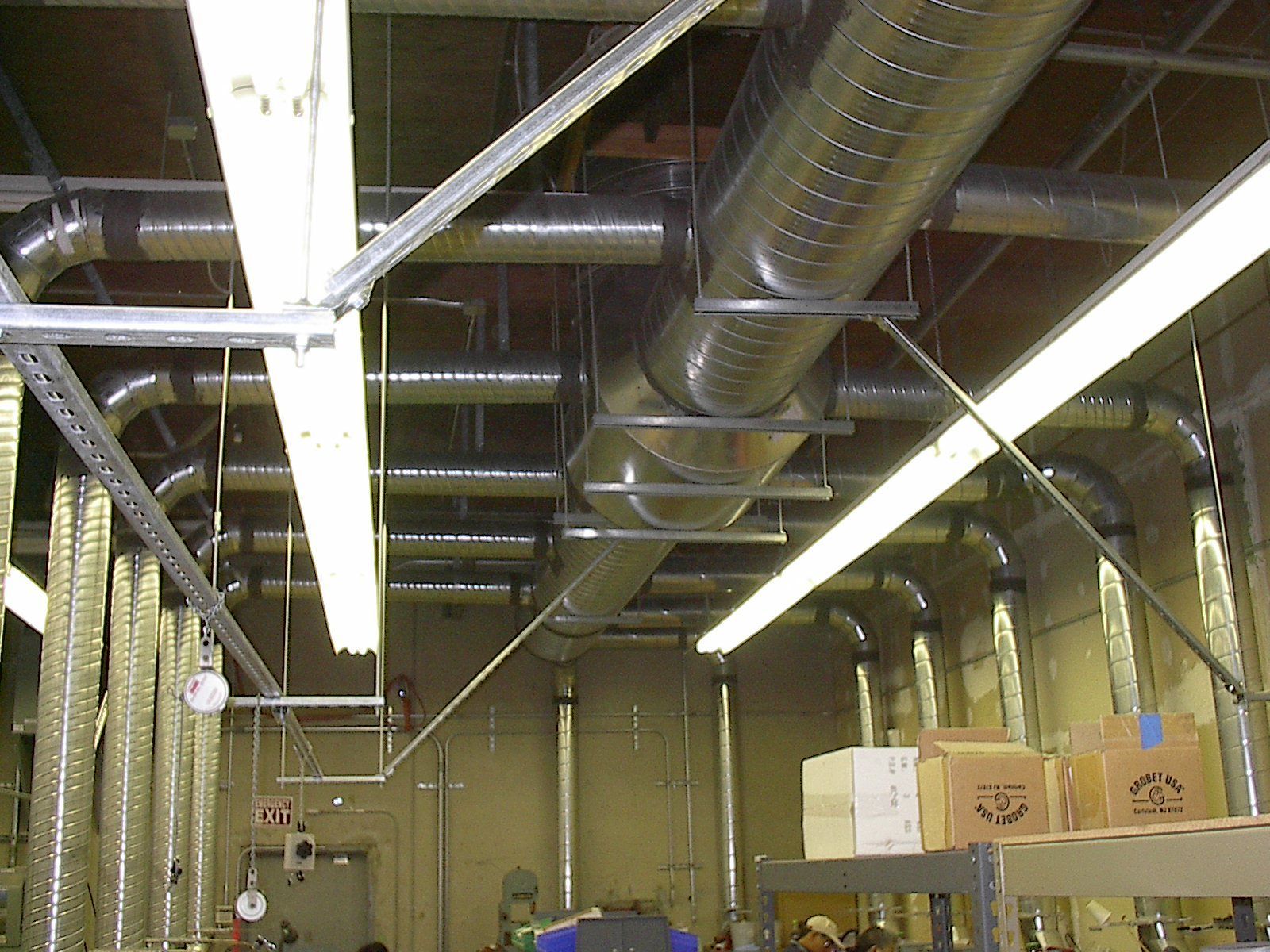 A warehouse with a lot of pipes and boxes on shelves, a metal fabrication project completed by Walter Mork Company