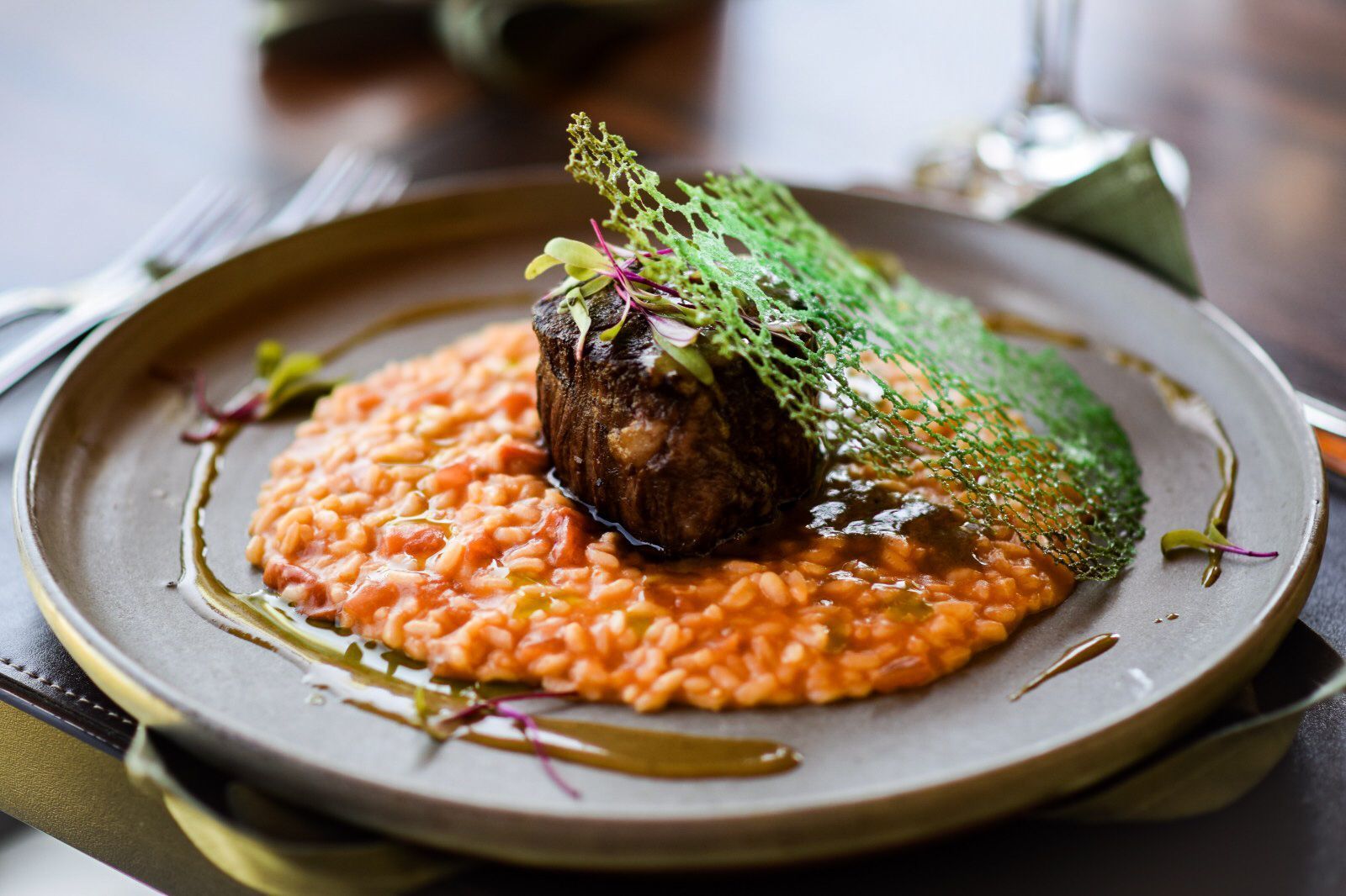 Um prato de comida com arroz e carne sobre uma mesa.