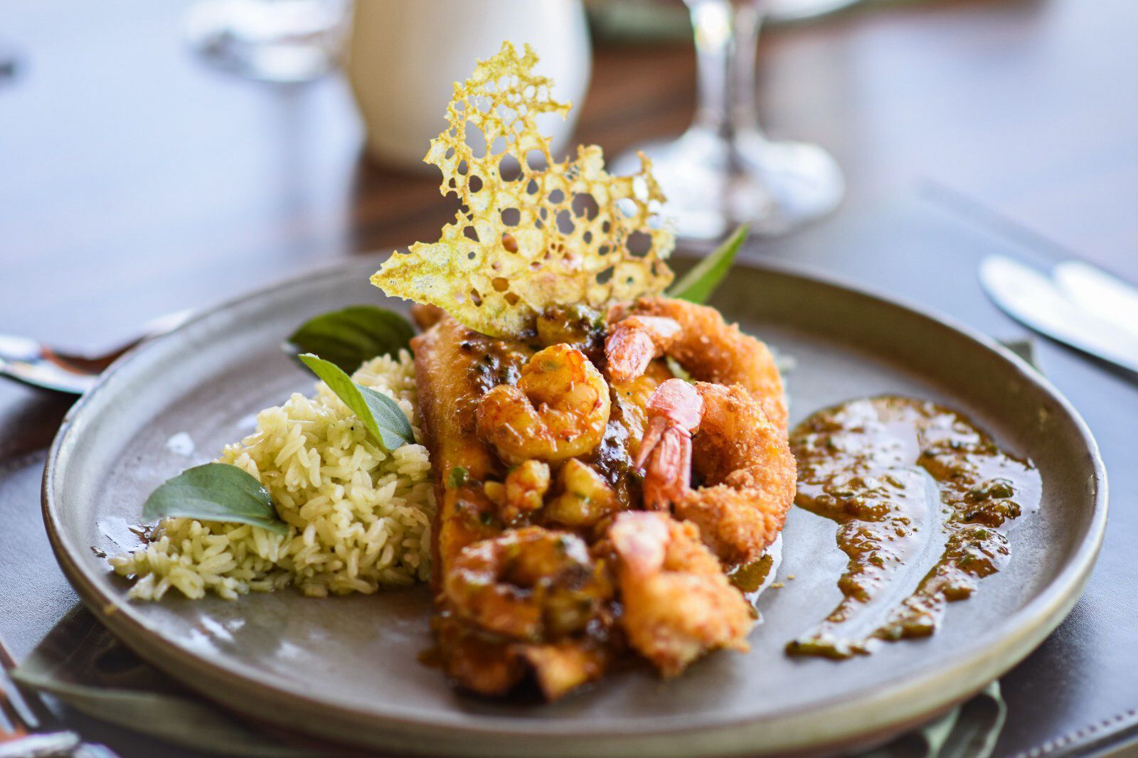 Um prato de comida com camarão e arroz sobre uma mesa.
