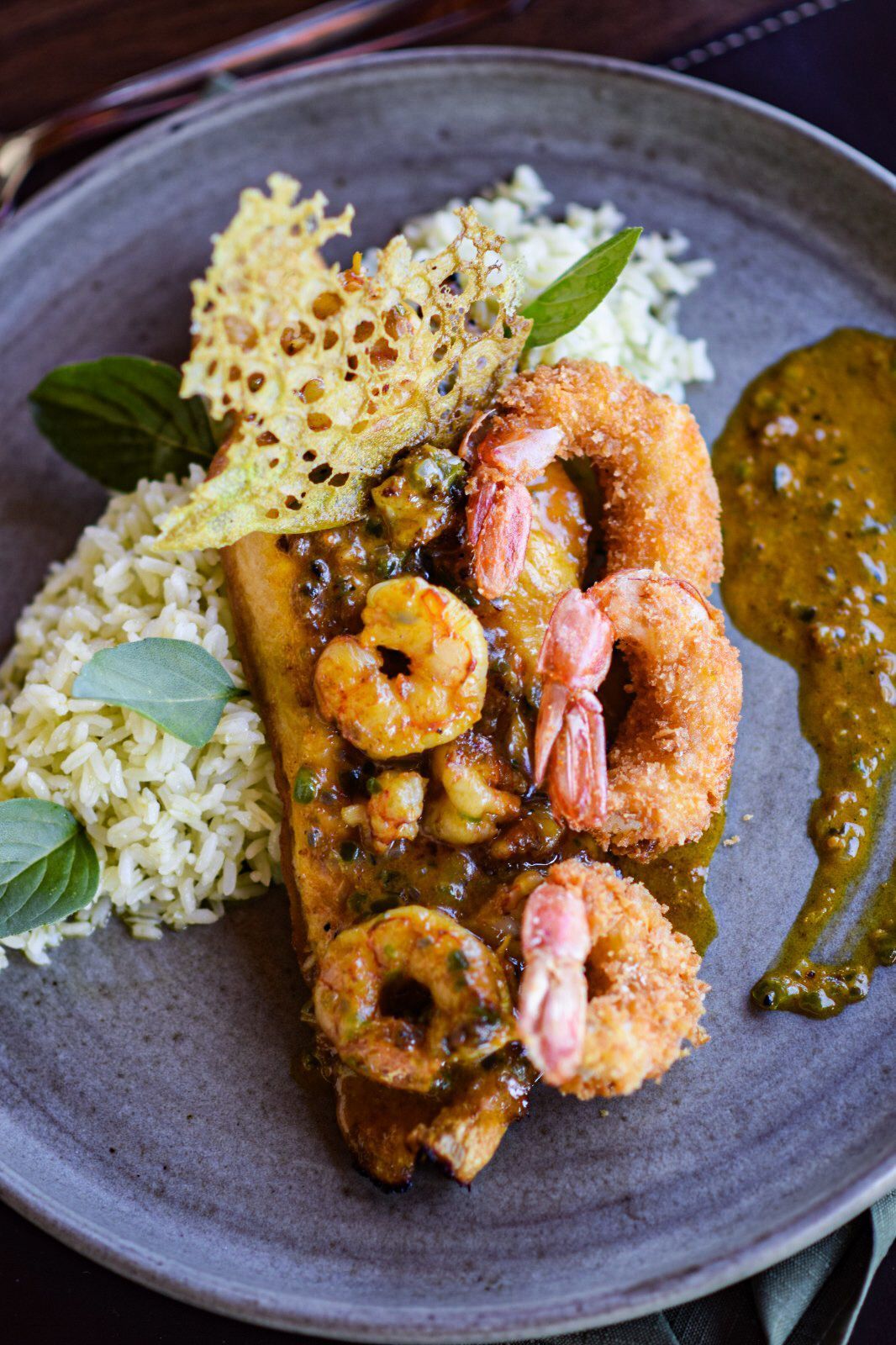 Um close de um prato de comida com camarão e arroz em uma mesa.