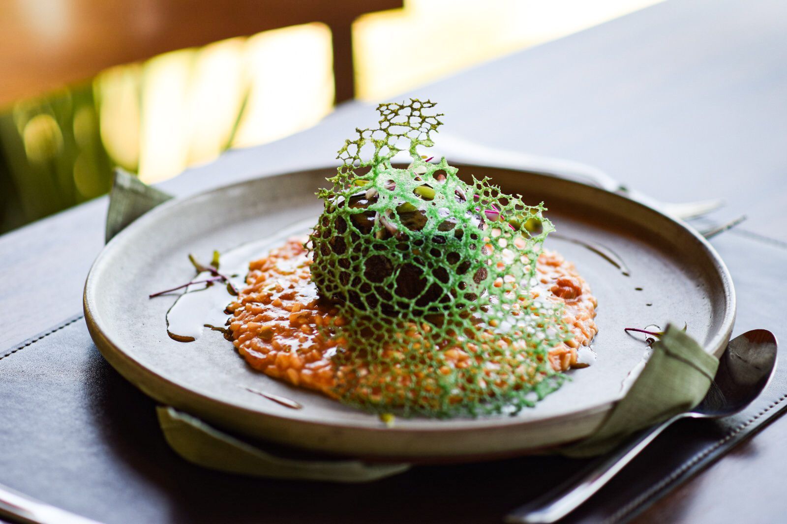 Um prato de comida com uma bola verde em cima dele sobre uma mesa.