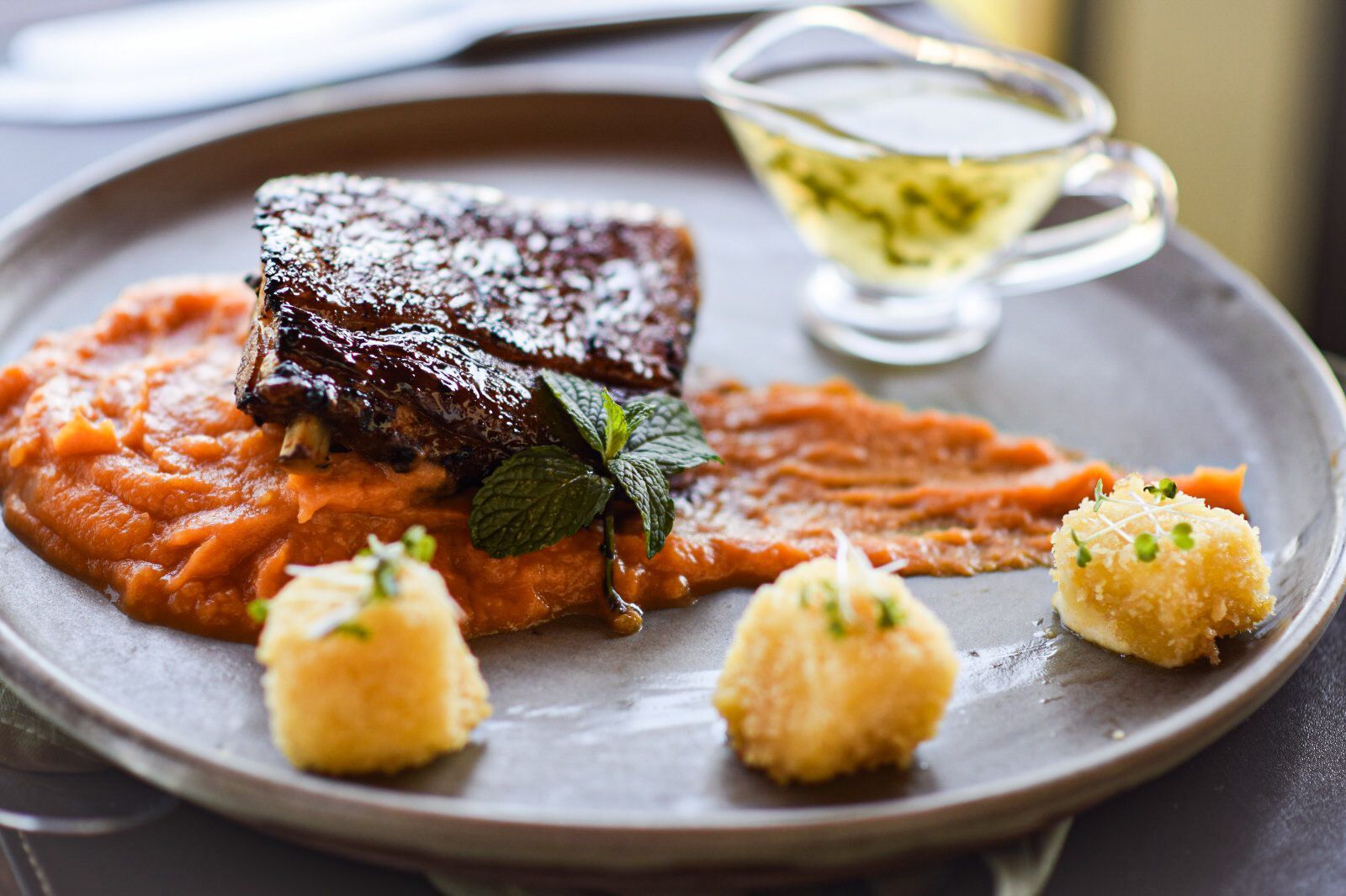 Um prato de comida com purê de batatas e carne sobre uma mesa.