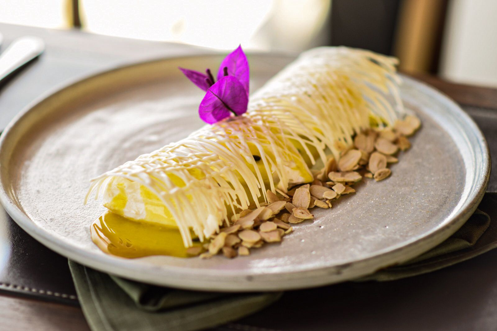 Um prato de comida com uma flor em cima dele sobre uma mesa.