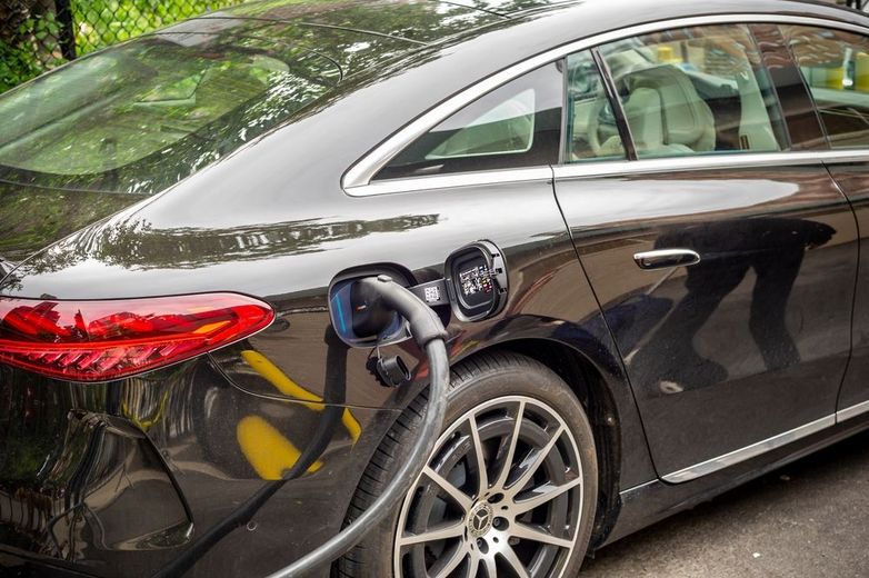 A black car is being charged at a charging station.