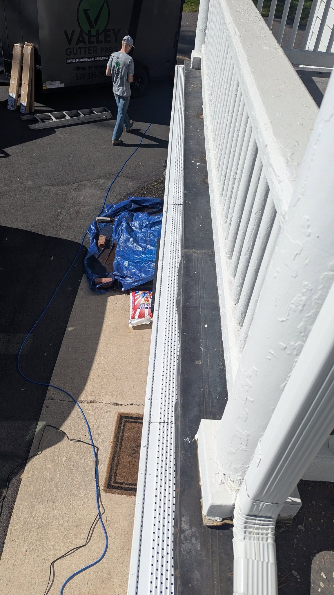 A man is laying on the ground next to a white railing.