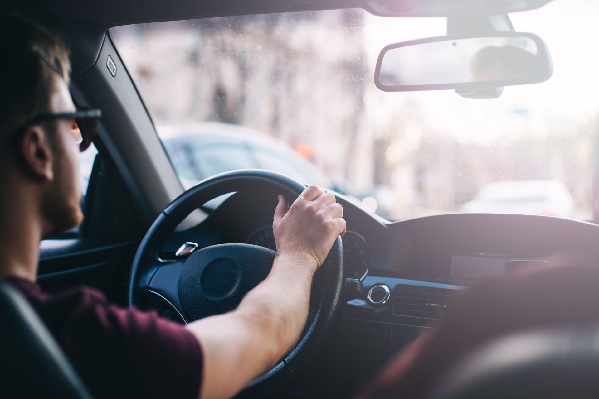 A man is driving a car on a city street