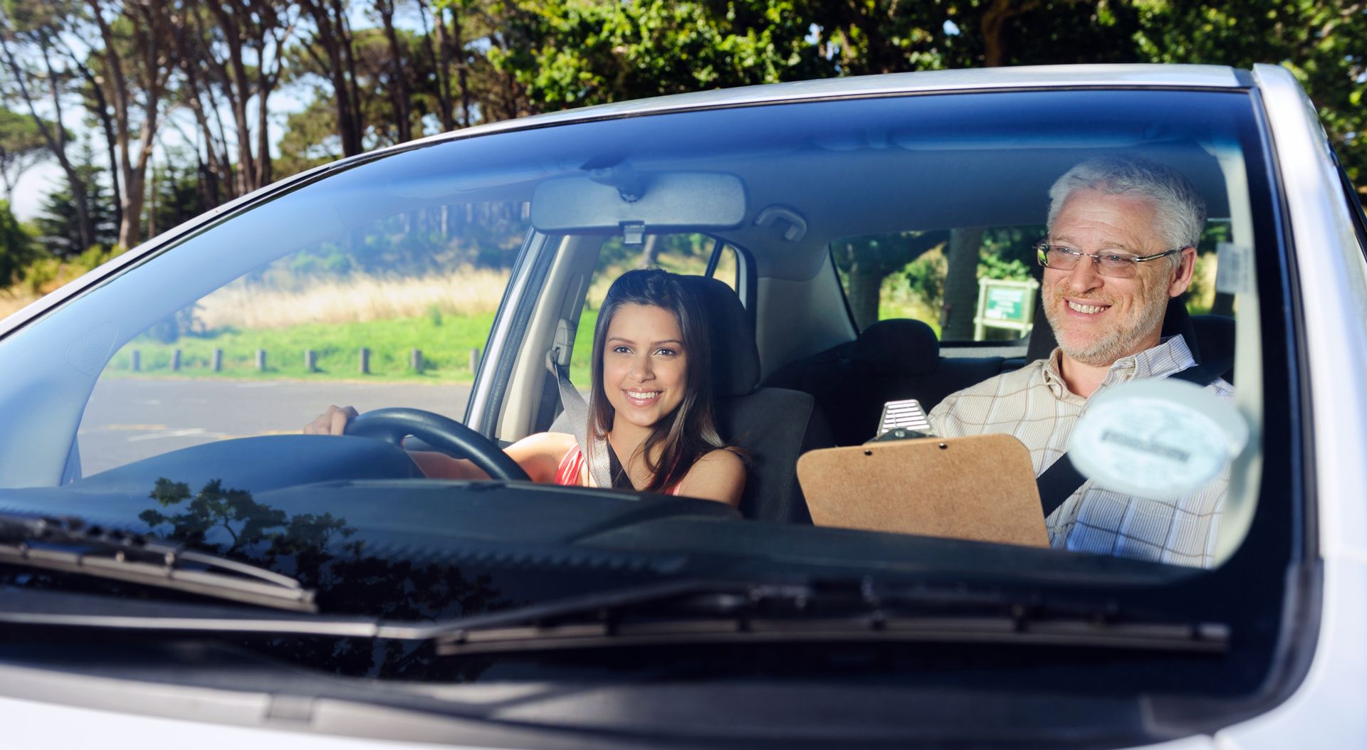 A man is teaching a woman how to drive a car