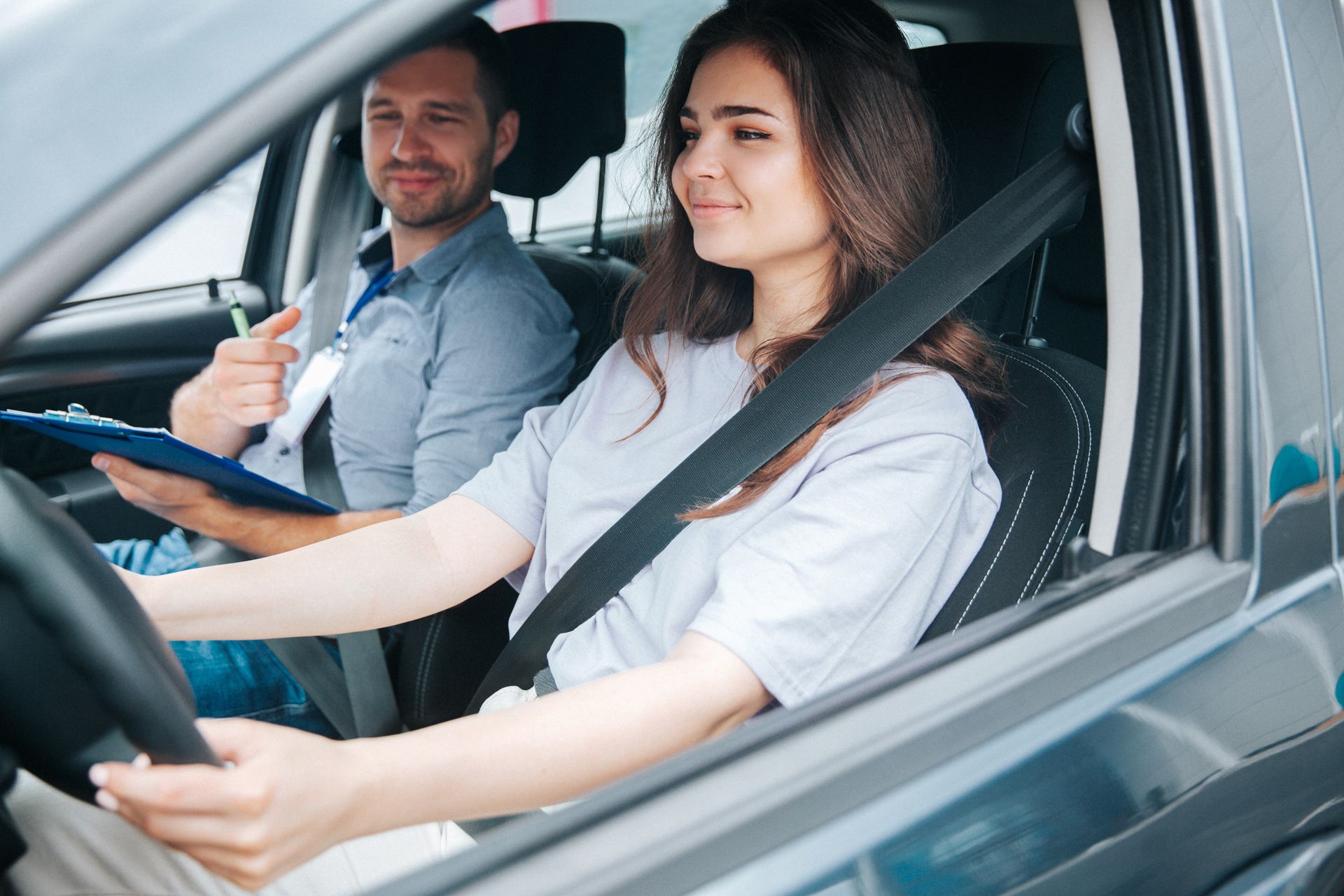 A man is teaching a woman how to drive a car