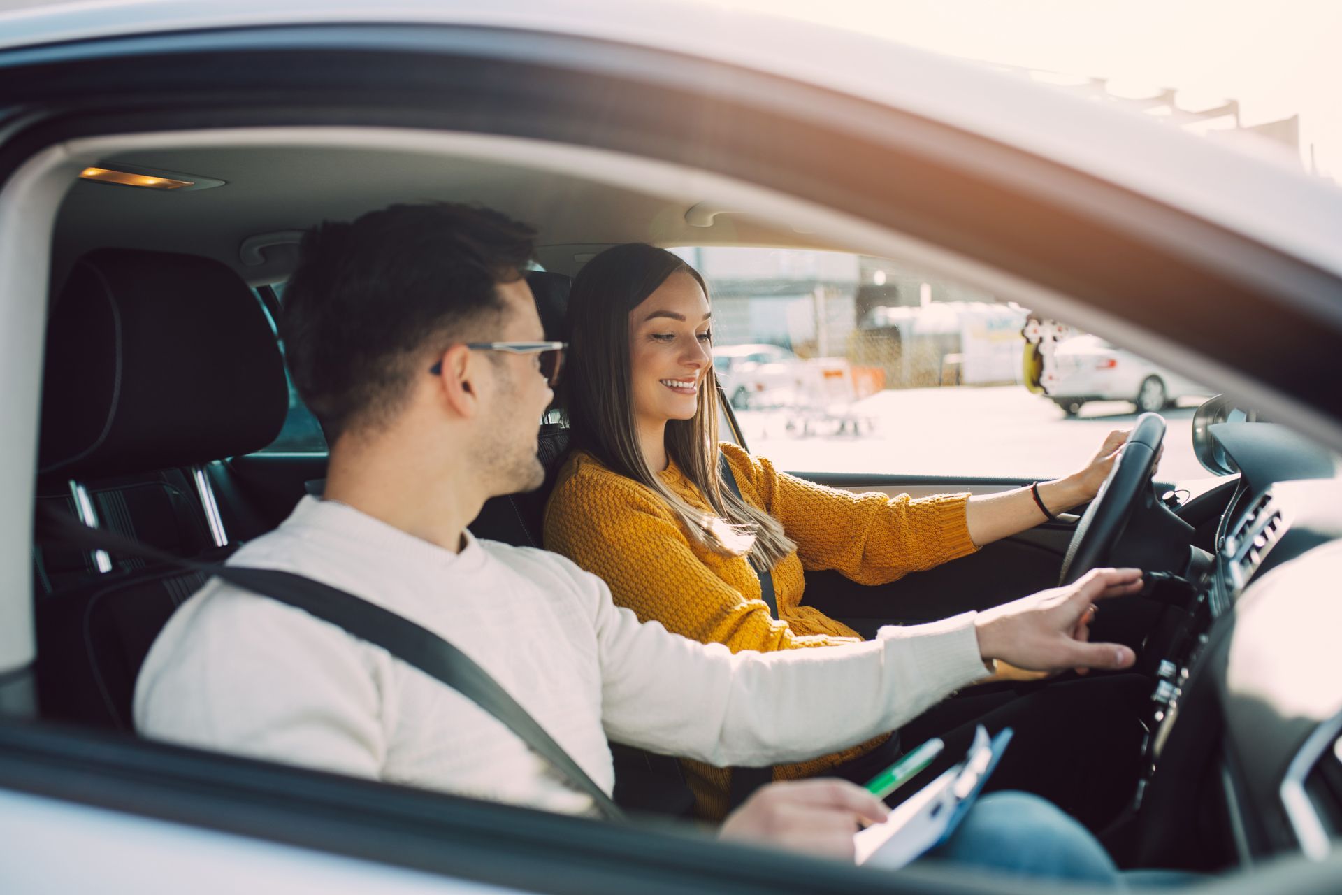 A man is teaching a woman how to drive a car