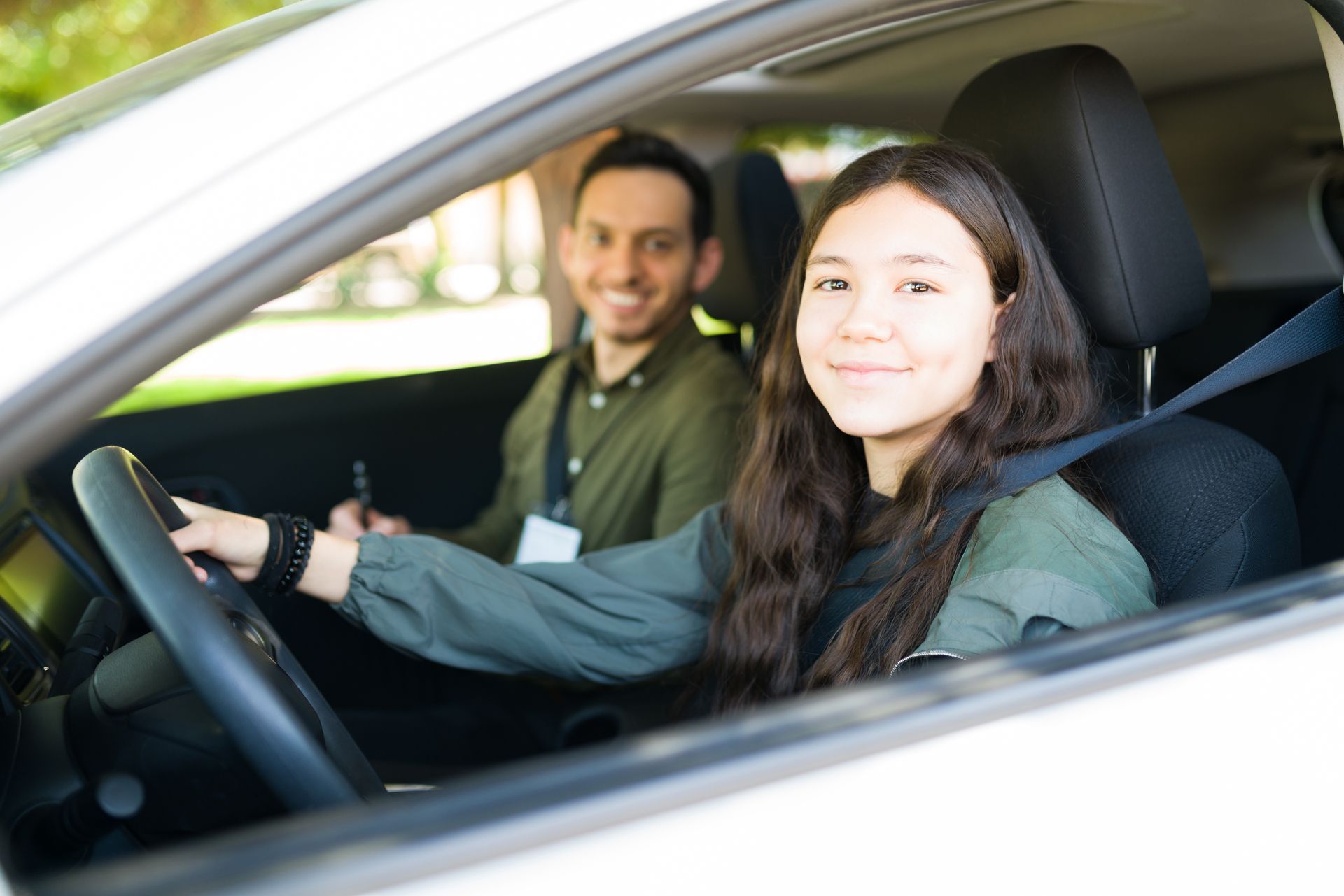 A man is teaching a woman how to drive a car