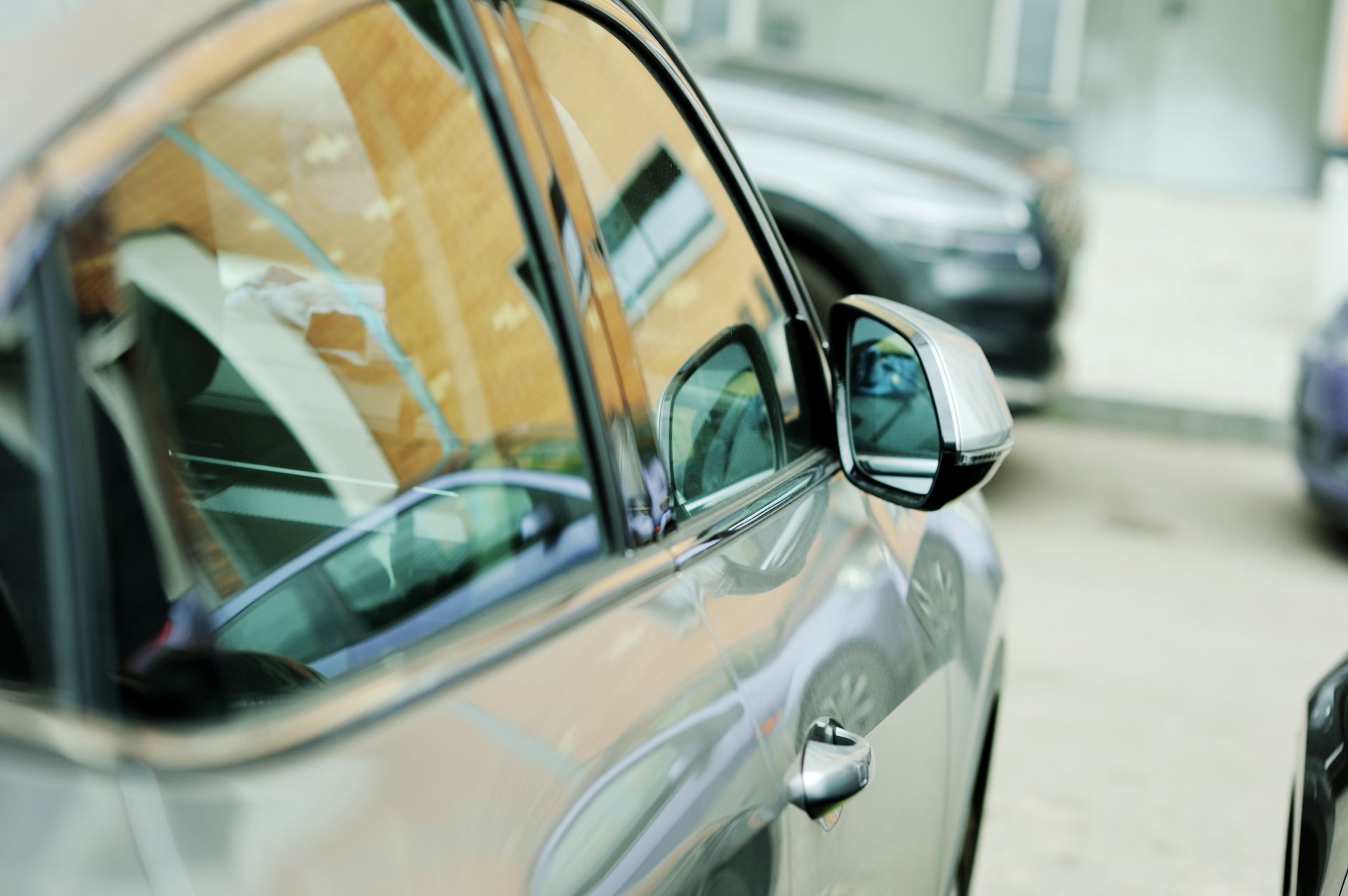 A car is parked in a parking lot with a building in the background