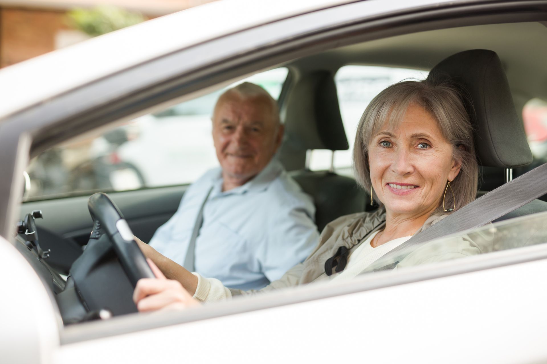 A man and a woman are sitting in a car