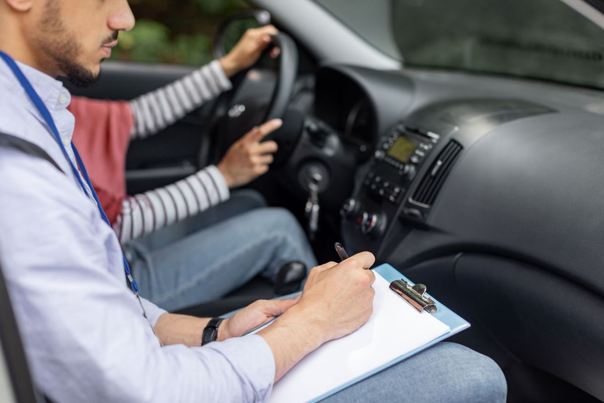 A man is teaching a woman how to drive a car