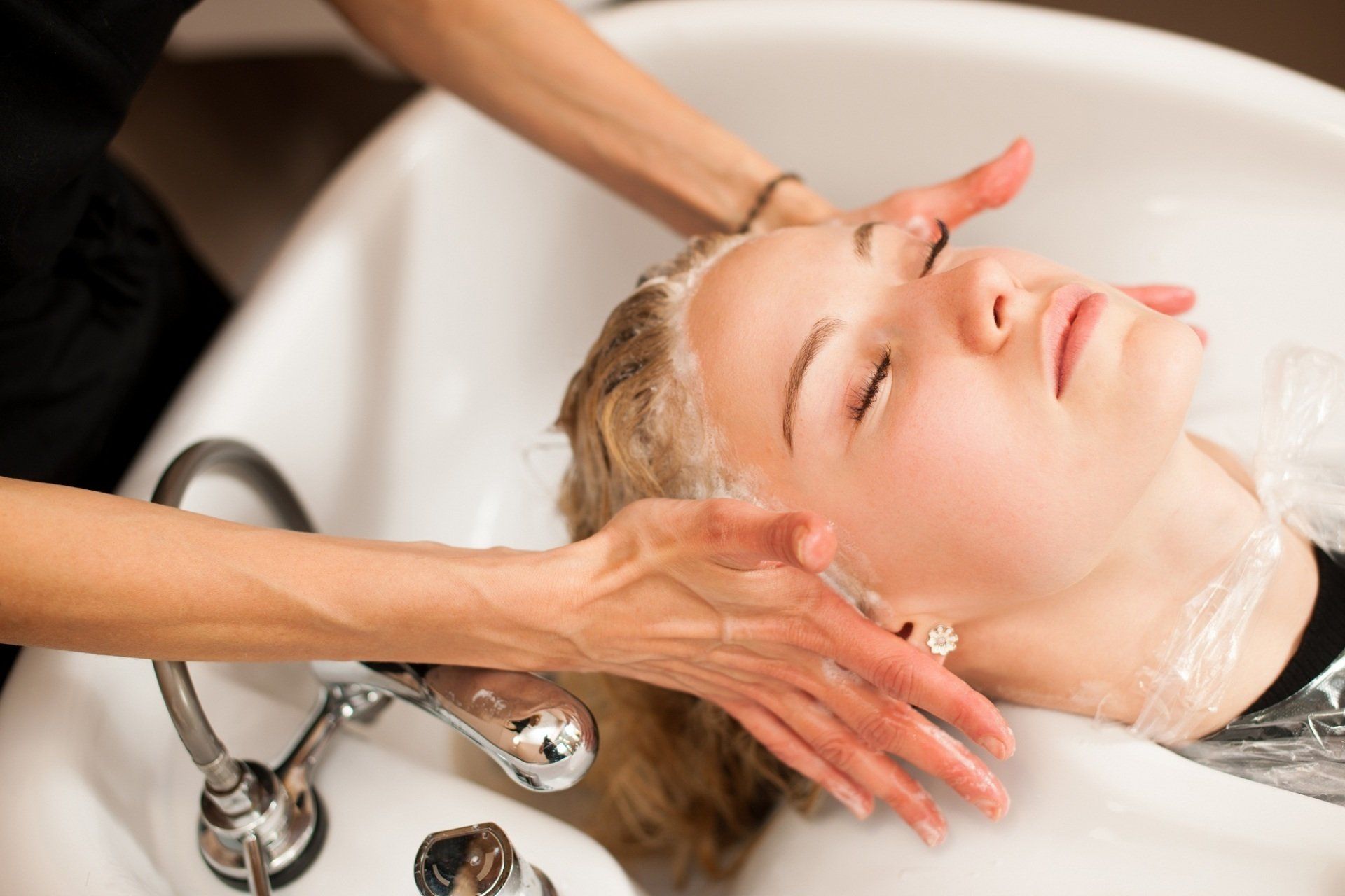 Una parrucchiera che lava i capelli di una cliente