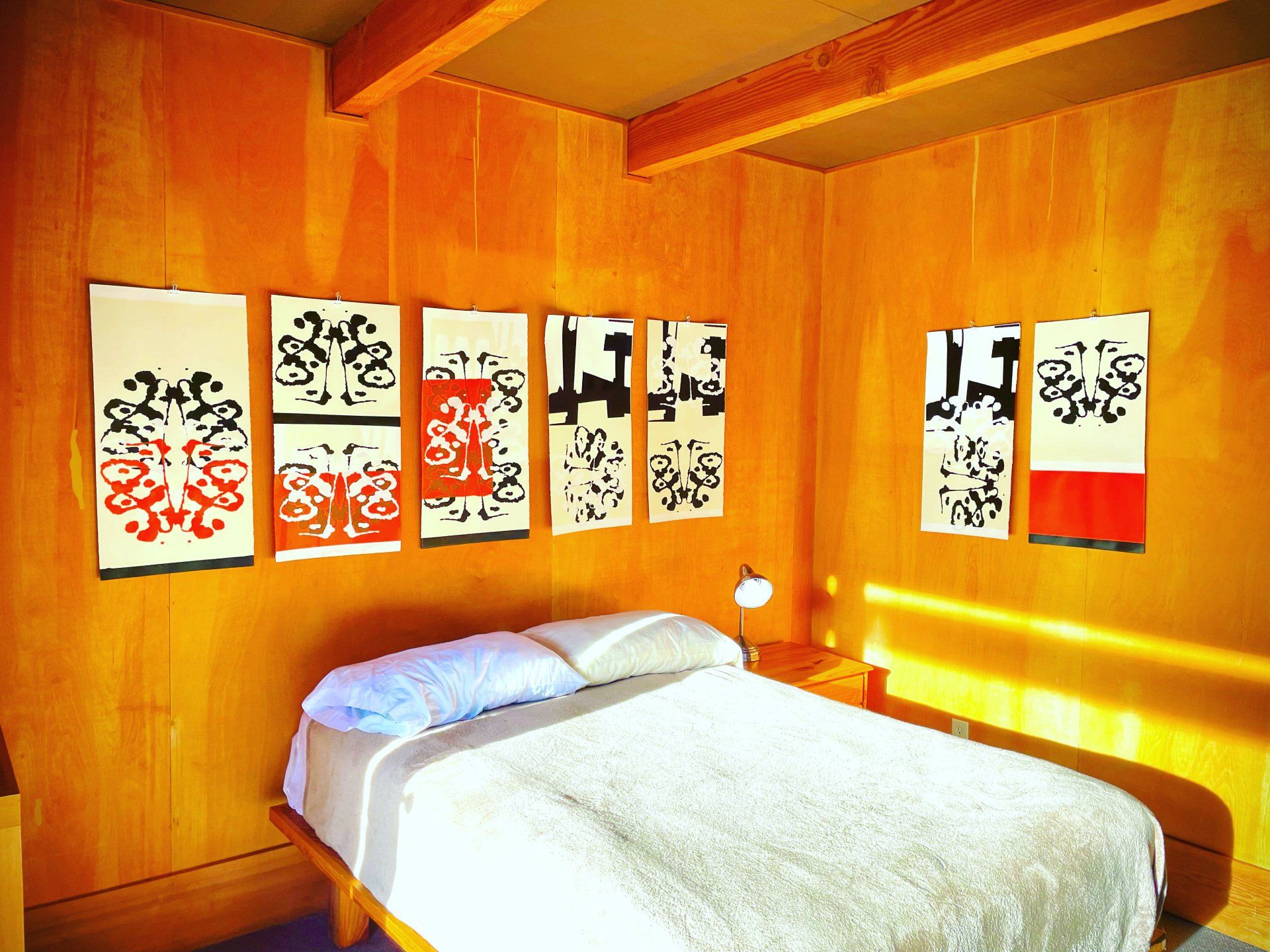 A bedroom with a bed and paintings on the wall