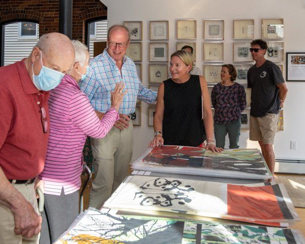A group of people are looking at paintings in a room