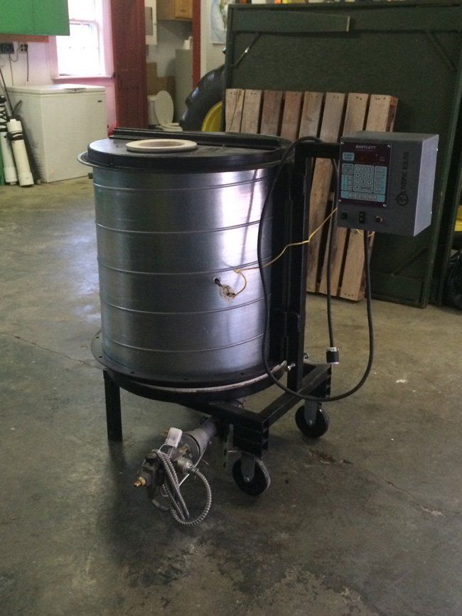 A large metal container on wheels with a control box attached to it