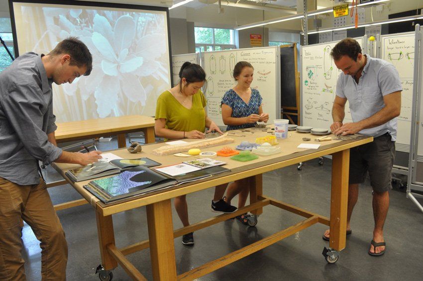 A group of people are working on a wooden table