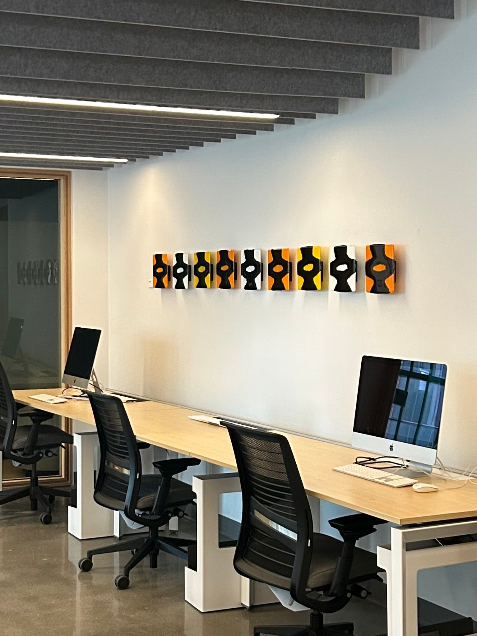A row of desks with computers and chairs in an office