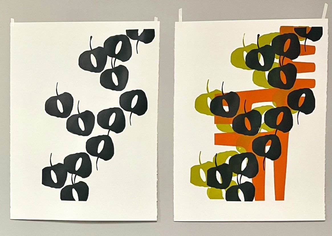 Two pieces of paper with black circles on them are hanging on a wall