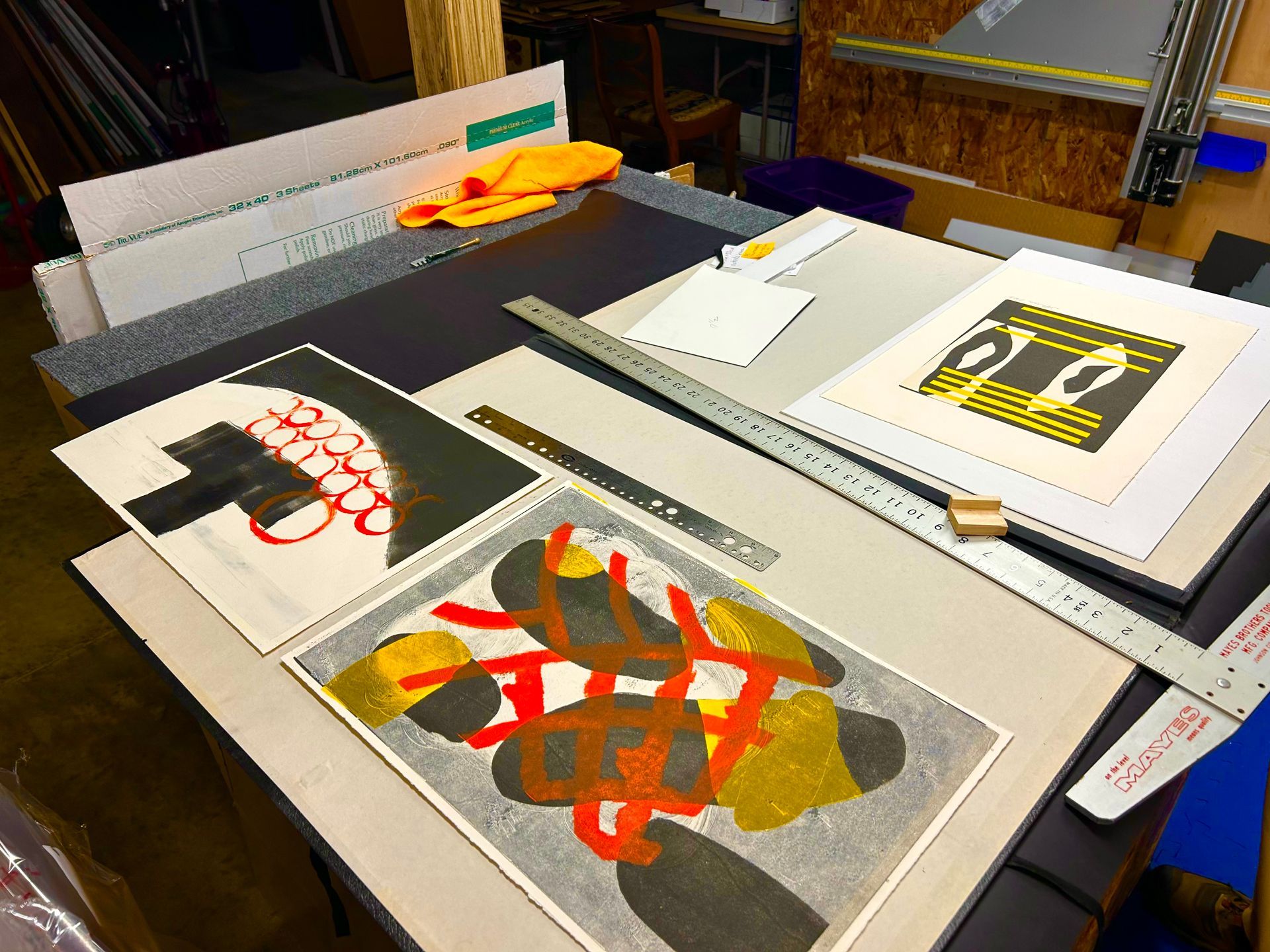 Several pieces of art on a table including one that says ' ao ' on it